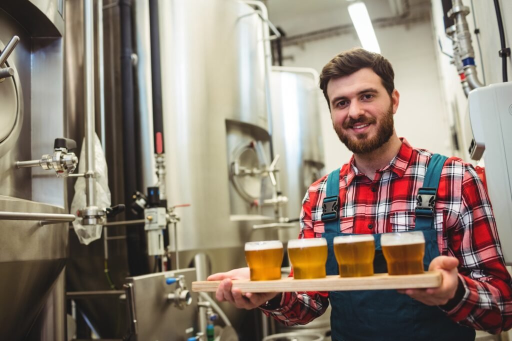 Manufacturer holding beer glasses in brewery