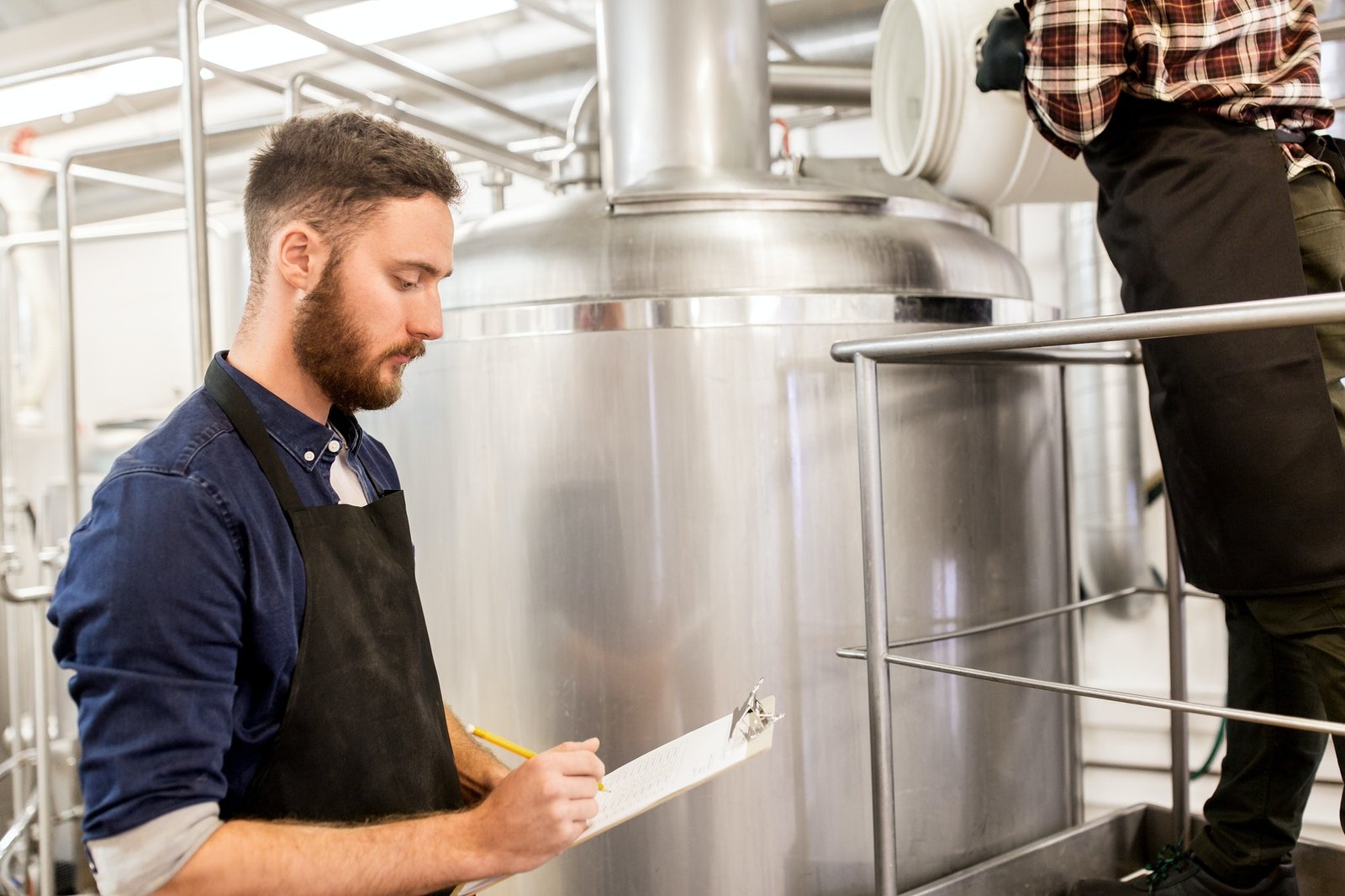 men working at craft brewery or beer plant